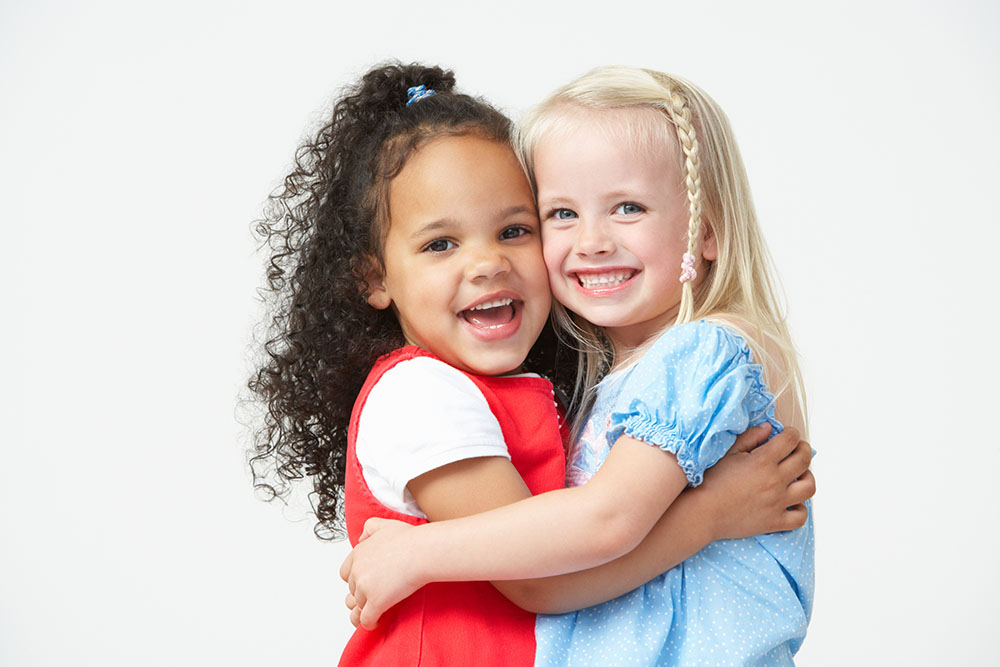 Two Pre School Girls Hugging One Another at a Preschool & Daycare Serving El Cajon, Lakeside and Santee CA